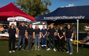 Eine Gruppe der Kreisjugendfeuerwehr steht vor ihrem Stand bei einem Aktionstag.